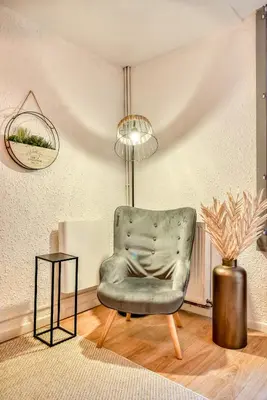 a living room with a chair and a table at Le Central - tout à pied - wifi in Carcassonne