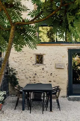 a black table and chairs in front of a building at Zero Neuf in Gaudiès