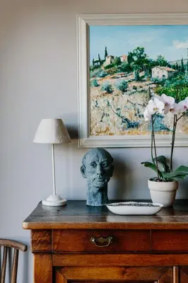 a bust on a table with a lamp and a painting at Zero Neuf in Gaudiès