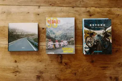 four magazines sitting on a wooden table at Zero Neuf in Gaudiès
