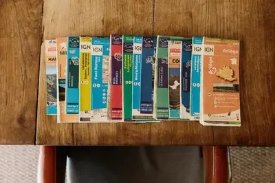 a bunch of books sitting on top of a wooden table at Zero Neuf in Gaudiès