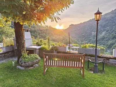 a park bench next to a tree and a street light at L'oustal in Lacrouzette
