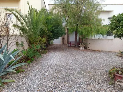 a courtyard of a house with trees and plants at Agréable maison de vacances in Port-la-Nouvelle