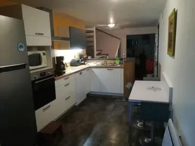 a small kitchen with white cabinets and a sink at Agréable maison de vacances in Port-la-Nouvelle