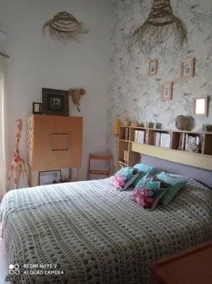 a bedroom with a bed with a comforter on it at Agréable maison de vacances in Port-la-Nouvelle