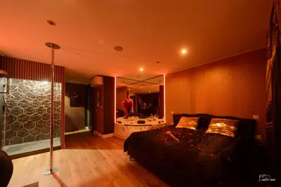 a room with pink lighting and a table with chairs at Shiny Cloud Love Room in Limoux