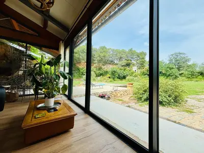 a room with a large glass window with a plant on a table at Architect's house Cleopatra luxury , private pool in heart of nature for 2 people in Quarante