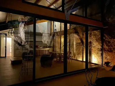 a room with a stone wall and a table and chairs at Architect's house Cleopatra luxury , private pool in heart of nature for 2 people in Quarante