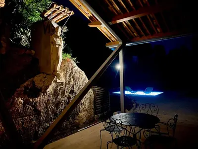 a table and chairs on a patio at night at Architect's house Cleopatra luxury , private pool in heart of nature for 2 people in Quarante