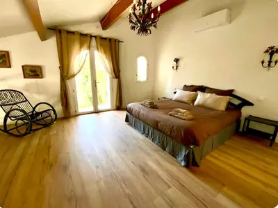 a bedroom with a bed and a large window at Architect's house Cleopatra luxury , private pool in heart of nature for 2 people in Quarante