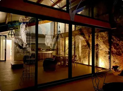 a room with a table and chairs and a stone wall at Architect's house Cleopatra luxury , private pool in heart of nature for 2 people in Quarante