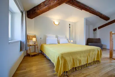 a bedroom with a large bed with a yellow bedspread at L'Oustalet - Single-family home with terrace Oustalet in Ferrals-lès-Corbières