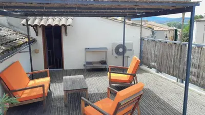 an outdoor deck with two chairs and a table at L'Oustalet - Single-family home with terrace Oustalet in Ferrals-lès-Corbières