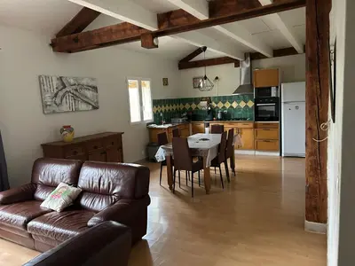 a living room with a couch and a table and a kitchen at Vistetta in Narbonne