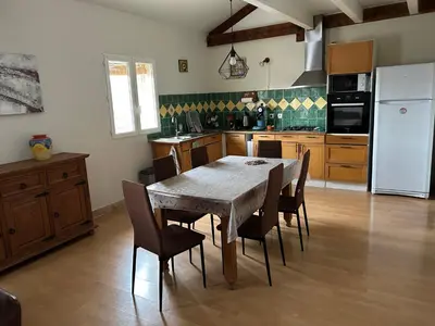 a kitchen with a table and chairs and a white refrigerator at Vistetta in Narbonne