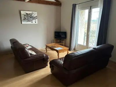 a living room with a leather couch and a table at Vistetta in Narbonne