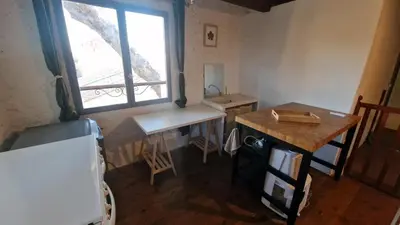 a kitchen with a table and a window and a desk at Le logis des vendangeurs in Puisserguier