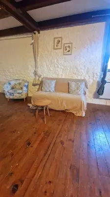 a bedroom with a bed and a wooden floor at Le logis des vendangeurs in Puisserguier