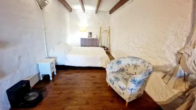 a bedroom with a bed and a chair in it at Le logis des vendangeurs in Puisserguier