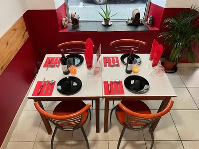 a table in a restaurant with red decorations on it at Hernesto in Carcassonne