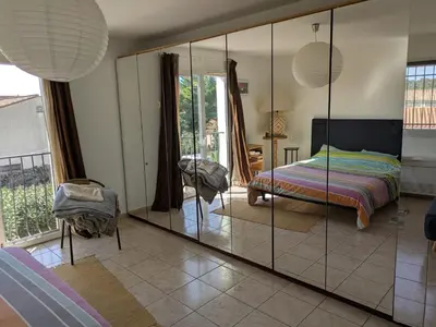 a bedroom with a mirror and a bed and a chair at Maison proche mer - 5 couchages - ideal planchistes in Lapalme