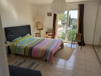 a bedroom with a bed and a view of a balcony at Maison proche mer - 5 couchages - ideal planchistes in Lapalme