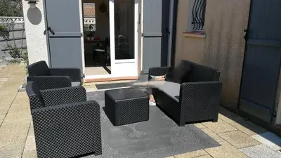 a group of chairs and a table in front of a door at Maison proche mer - 5 couchages - ideal planchistes in Lapalme