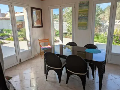 a dining room with a glass table and chairs at Maison proche mer - 5 couchages - ideal planchistes in Lapalme
