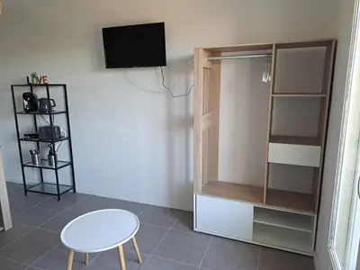 a room with a tv and a table and a chair at studio proche Narbonne centre in Narbonne