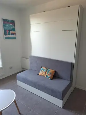 a couch with a pillow on it in a room at studio proche Narbonne centre in Narbonne