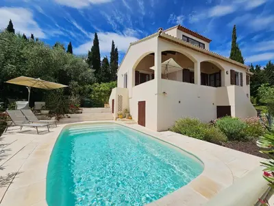 a villa with a swimming pool in front of a house at Sourire du Soleil in Montouliers