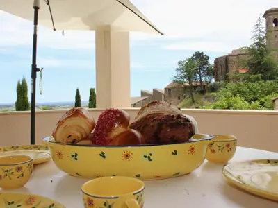 a bowl of food sitting on a table with plates at Sourire du Soleil in Montouliers