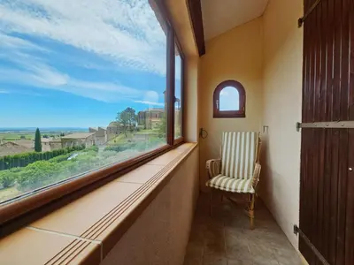 a chair sitting in a room with a large window at Sourire du Soleil in Montouliers