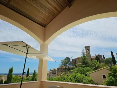 a view from a porch with a view of a building at Sourire du Soleil in Montouliers