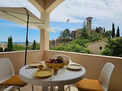 a table with a bowl of fruit on a balcony at Sourire du Soleil in Montouliers