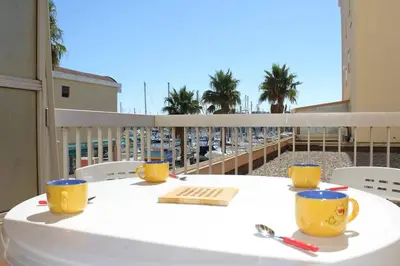 a table on a balcony with a view of the ocean at Appartement Studio Cabine - Gruissan GN110-C13 in Gruissan