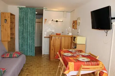 a small room with a table and a kitchen at Appartement Studio Cabine - Gruissan GN110-C13 in Gruissan