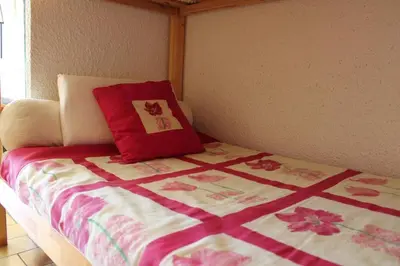 a bed with a red pillow on top of it at Appartement Studio Cabine - Gruissan GN110-C13 in Gruissan