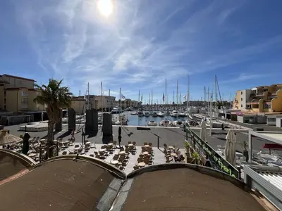 a marina with a bunch of people sitting on a patio at Appartement 2 pièces cabine - Gruissan GN130-820 in Gruissan