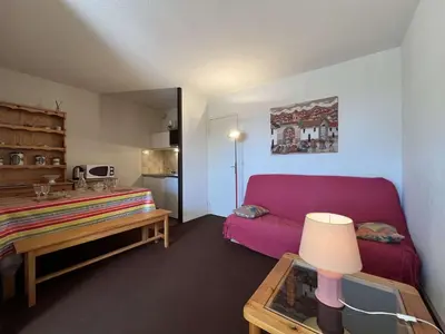 a living room with a red couch and a table at Appartement 2 pièces cabine - Gruissan GN130-820 in Gruissan