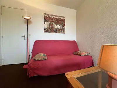 a red couch with two pillows sitting in a room at Appartement 2 pièces cabine - Gruissan GN130-820 in Gruissan