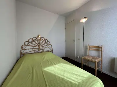 a bedroom with a green bed and a chair at Appartement 2 pièces cabine - Gruissan GN130-820 in Gruissan