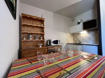 a kitchen with a table with wine glasses on it at Appartement 2 pièces cabine - Gruissan GN130-820 in Gruissan