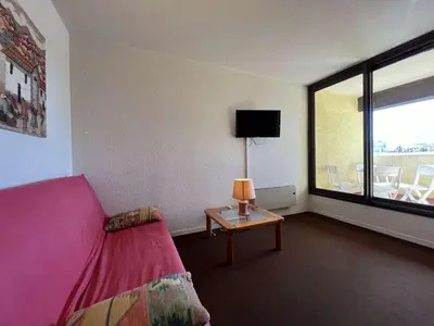 a room with a pink couch and a table with a lamp at Appartement 2 pièces cabine - Gruissan GN130-820 in Gruissan