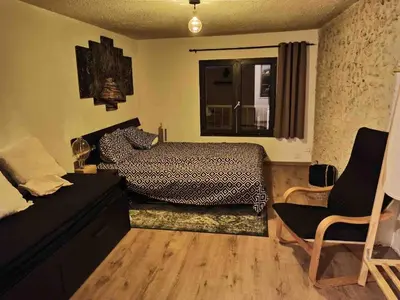 a bedroom with a bed and a window and a chair at Cœur d 'amande in Narbonne