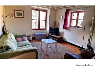 a living room with a couch and a table at Maison QUÉRIGUT in Quérigut