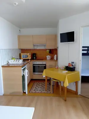a small kitchen with a table and a yellow table cloth at Appartement 6 personnes Gruissan in Gruissan