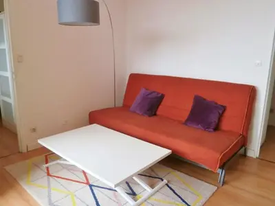 a red couch with two purple pillows and a table at Appartement 6 personnes Gruissan in Gruissan