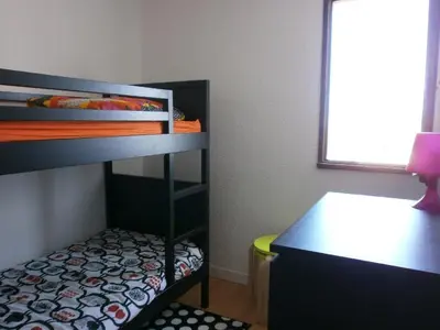 a small room with a bunk bed and a desk at Appartement 6 personnes Gruissan in Gruissan