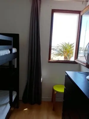 a bedroom with a window and a desk and a chair at Appartement 6 personnes Gruissan in Gruissan